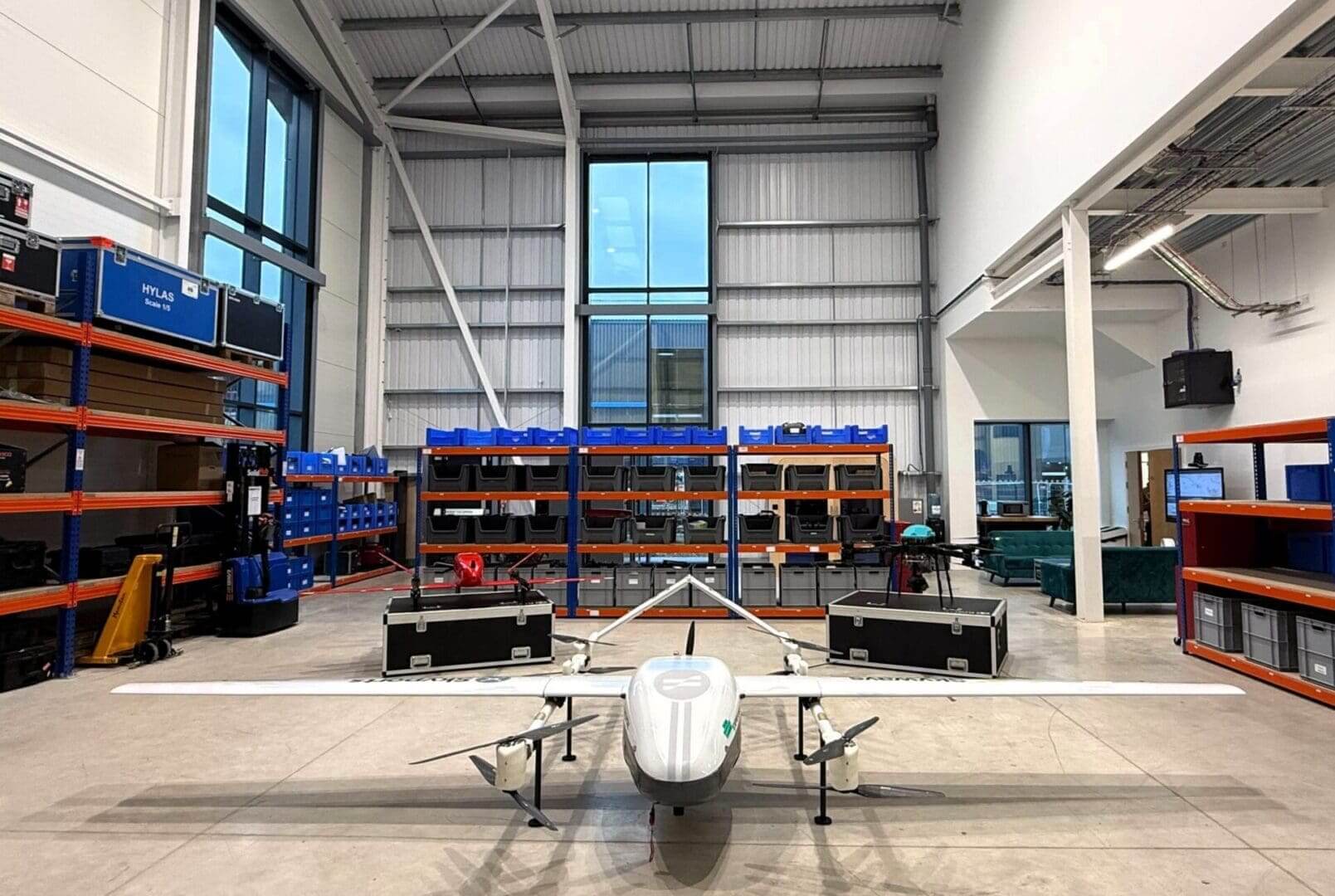Drone in industrial warehouse with shelves.