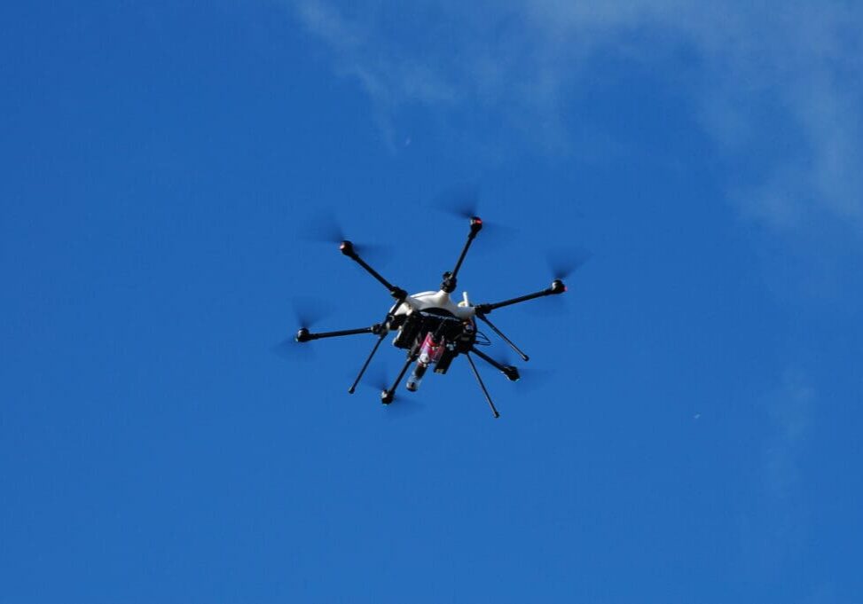 Here's an alt tag for the image: Hexacopter drone in blue sky